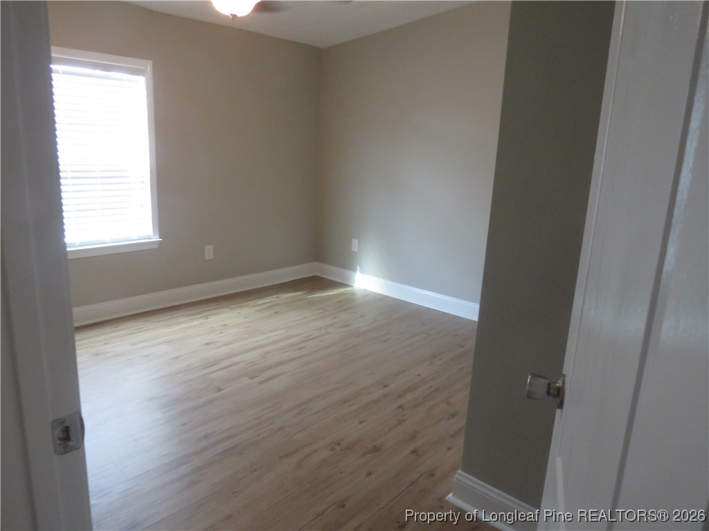 1184 Fisher Road St. Pauls, NC 28384 - Photo 21 of 29 an empty room with wooden floor and windows