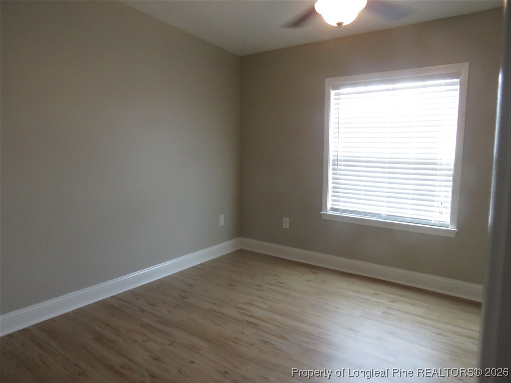 1184 Fisher Road St. Pauls, NC 28384 - Photo 22 of 29 a view of an empty room with wooden floor and a window