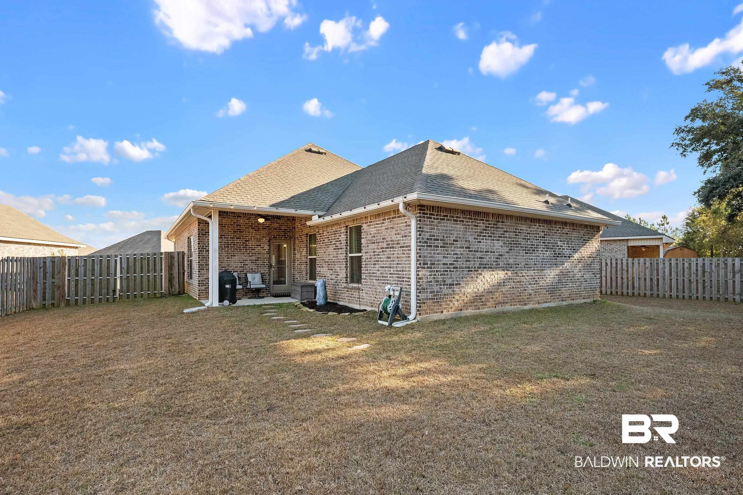 1077 Stella Road Foley, AL 36535 - Photo 24 of 27 Rear view of property with a fenced backyard, a patio area, brick siding, and a shingled roof