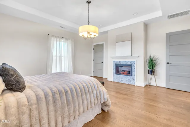 a spacious bedroom with a bed and a chandelier