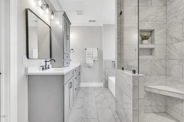 a bathroom with a double vanity sink mirror and shower