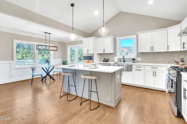 a kitchen with a table chairs refrigerator and cabinets