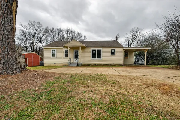 a front view of house with yard and trees around