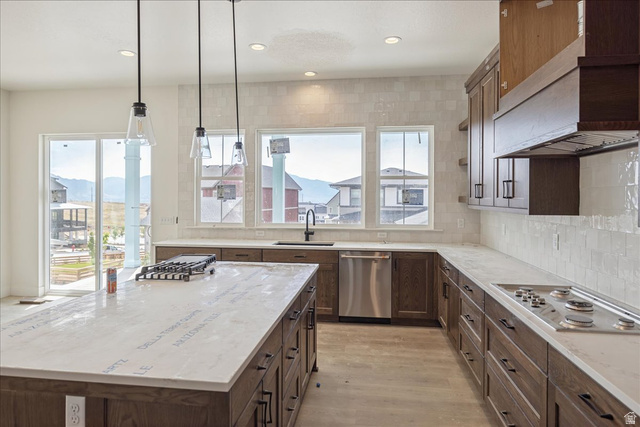 7189 South Sage Road, Unit 214 West Jordan, UT 84081 - Photo 8 of 29 Gourmet kitchen featuring a large central island, white countertops, dark wood cabinetry, a built-in gas cooktop, and stainless steel appliances