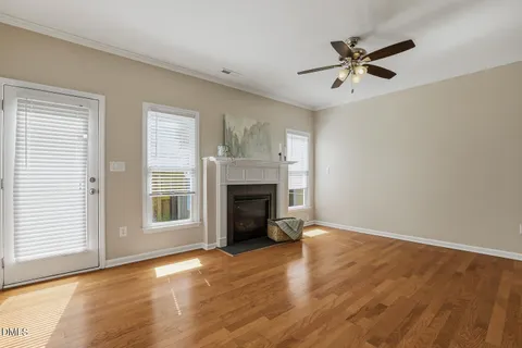 a view of a livingroom with a fireplace window and wooden floor