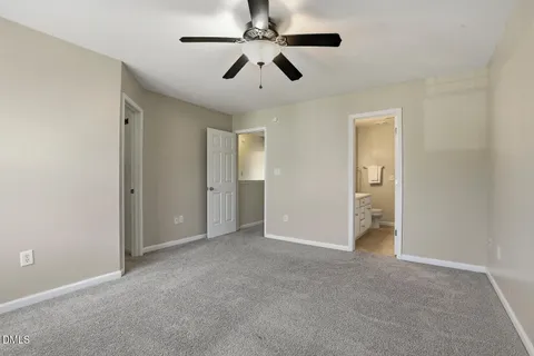 an empty room with closet and a ceiling fan