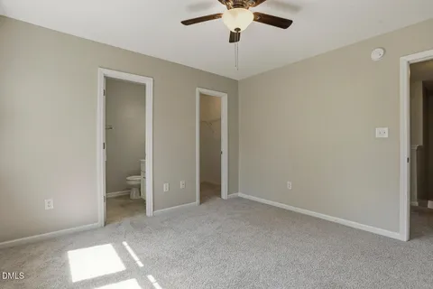 an empty room with a ceiling fan and a window