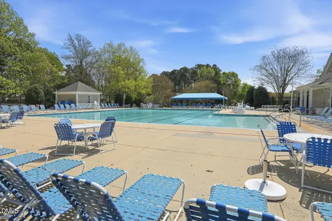 a view of a patio with dining table and chairs with wooden floor and fence