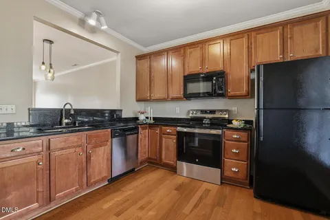 a kitchen with stainless steel appliances granite countertop a refrigerator stove and sink