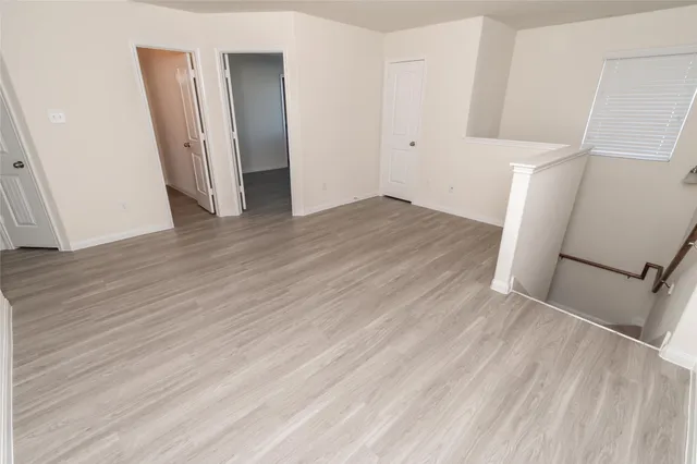 an empty room with wooden floor and white walls