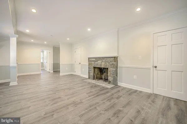 a view of empty room with wooden floor and fireplace