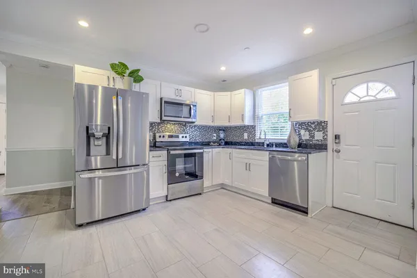 a kitchen with white cabinets and stainless steel appliances