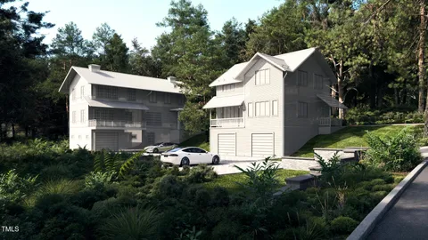 a view of a house with a small yard and large trees