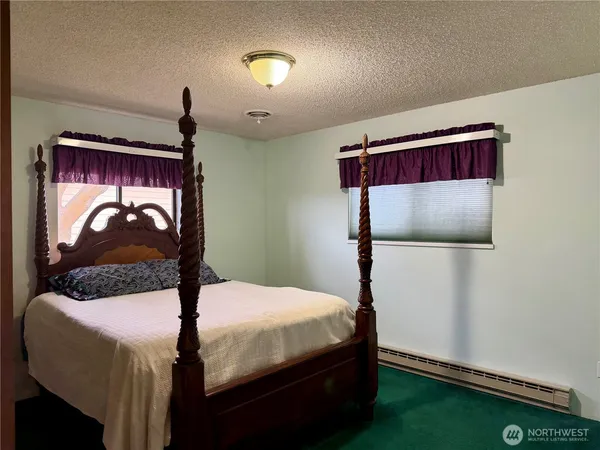 a bedroom with a bed and a painting on the wall