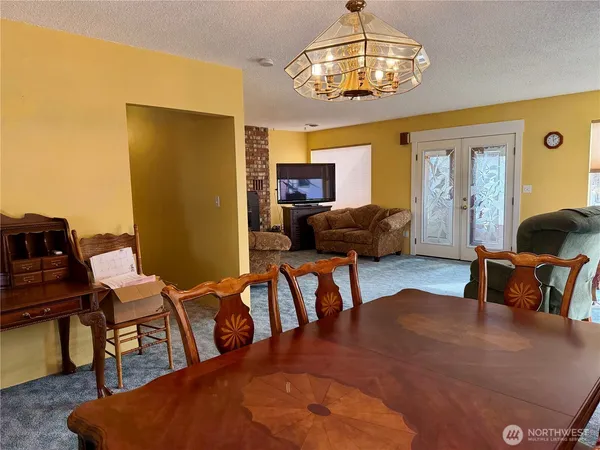 a living room with furniture chandelier and a dining table