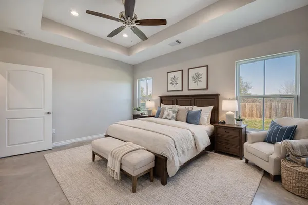 a spacious bedroom with a bed couch and window