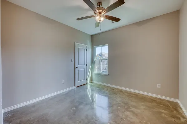 an empty room with chandelier fan