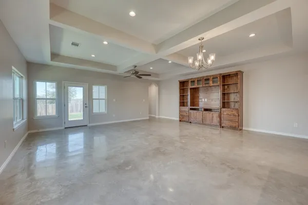 a view of an empty room with glass door and windows