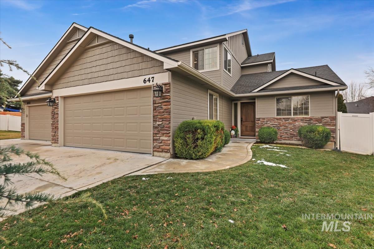 Craftsman-style house featuring stone siding, concrete driveway, and a two-car garage