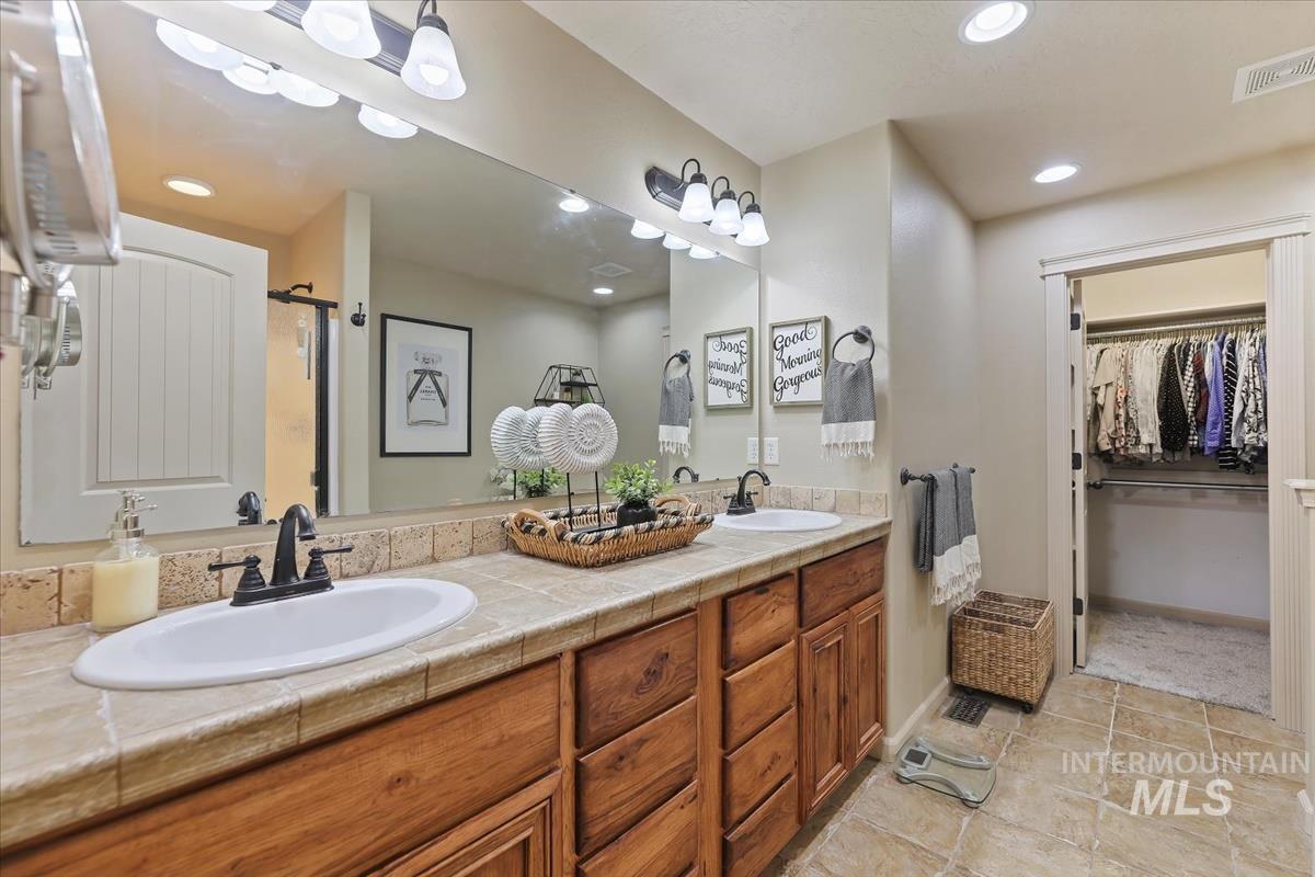 647 North Shadowfox Place Eagle, ID 83616 - Photo 17 of 35 Full bathroom featuring double vanity, a walk-in closet, recessed lighting, and an enclosed shower