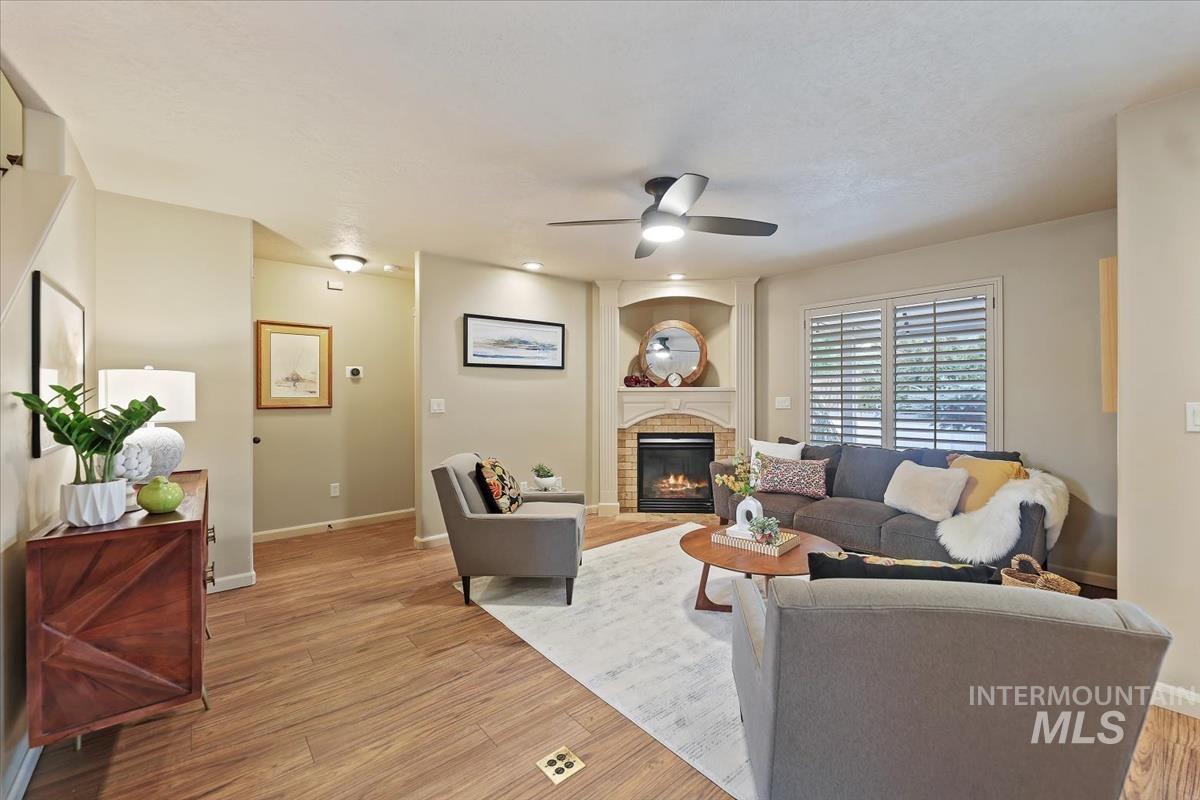 647 North Shadowfox Place Eagle, ID 83616 - Photo 2 of 35 Living area featuring LVP floors, a glass covered fireplace, and ceiling fan