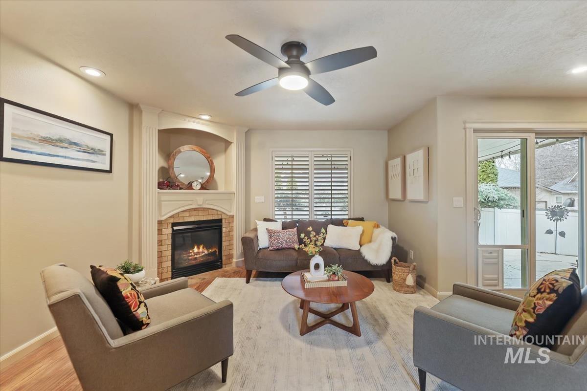 647 North Shadowfox Place Eagle, ID 83616 - Photo 3 of 35 Living area featuring a brick fireplace, healthy amount of natural light, ceiling fan, LVP floors, and recessed lighting