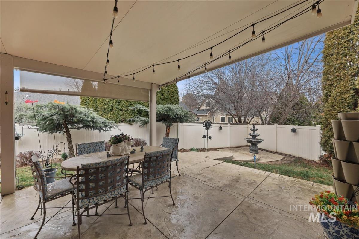 647 North Shadowfox Place Eagle, ID 83616 - Photo 31 of 35 Fenced backyard with a covered patio, outdoor dining area and a working fountain