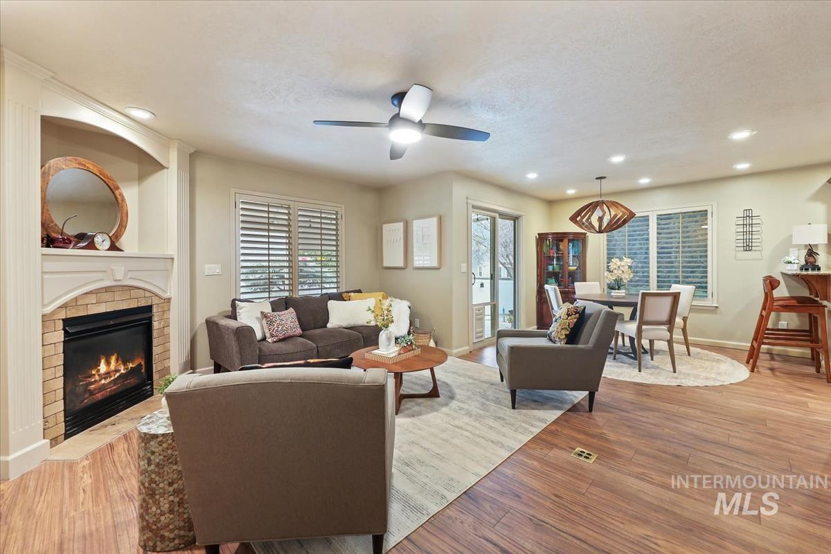 647 North Shadowfox Place Eagle, ID 83616 - Photo 4 of 35 Living area featuring LVP flooring, recessed lighting, a fireplace, and a ceiling fan