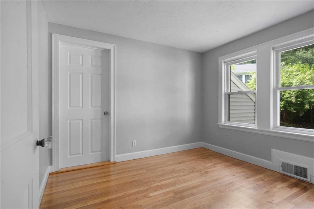 23 Marshall Road Natick, MA 01760 - Photo 15 of 31 a view of an empty room with wooden floor and a window