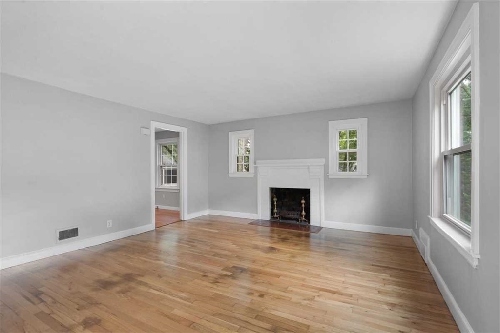23 Marshall Road Natick, MA 01760 - Photo 3 of 31 an empty room with windows and fireplace