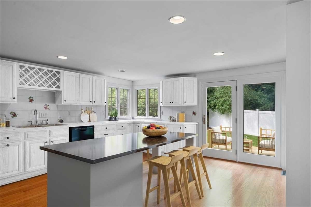 23 Marshall Road Natick, MA 01760 - Photo 6 of 31 a kitchen with stainless steel appliances kitchen island sink stove and white cabinets with wooden floor