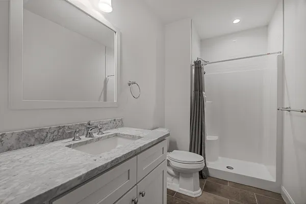 a bathroom with a granite countertop sink toilet and shower