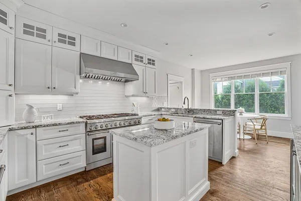 a kitchen with appliances cabinets and a wooden floor