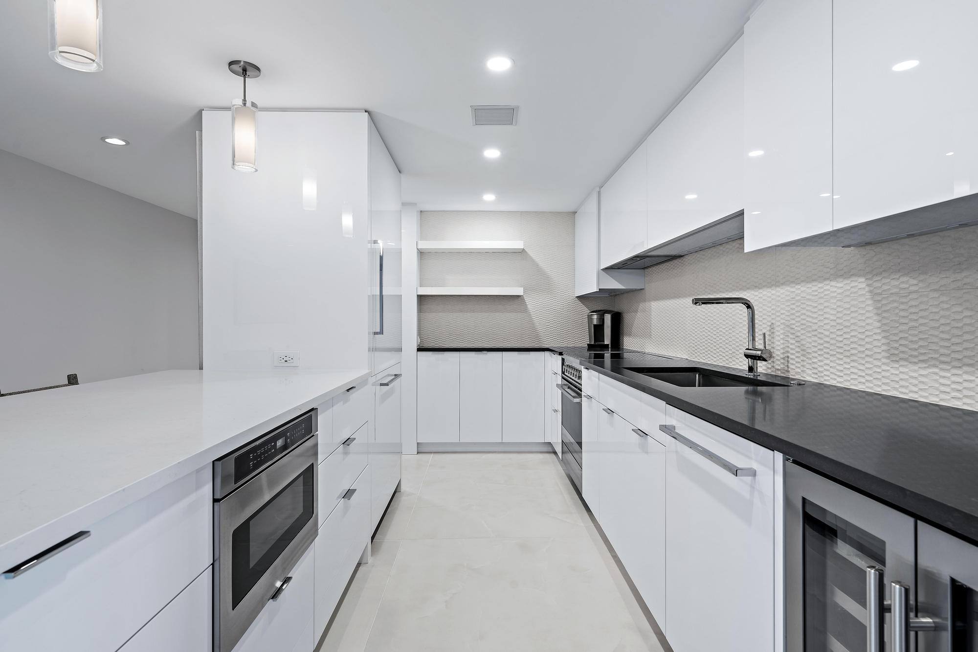 3456 South Ocean Boulevard, Unit 701 Palm Beach, FL 33480 - Photo 6 of 20 a large kitchen with granite countertop a large stove top oven and cabinets