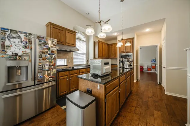 a kitchen with stainless steel appliances granite countertop a stove and cabinets