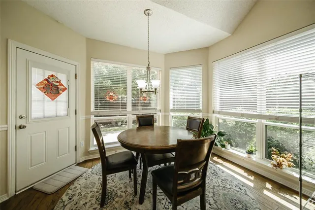 a dining room with furniture a chandelier and wooden floor
