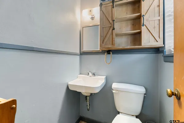 a bathroom with a toilet sink and mirror