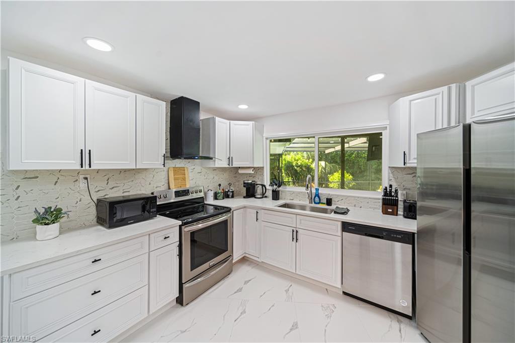 4439 Parrot Avenue Naples, FL 34104 - Photo 11 of 39 a kitchen with a sink stove and refrigerator