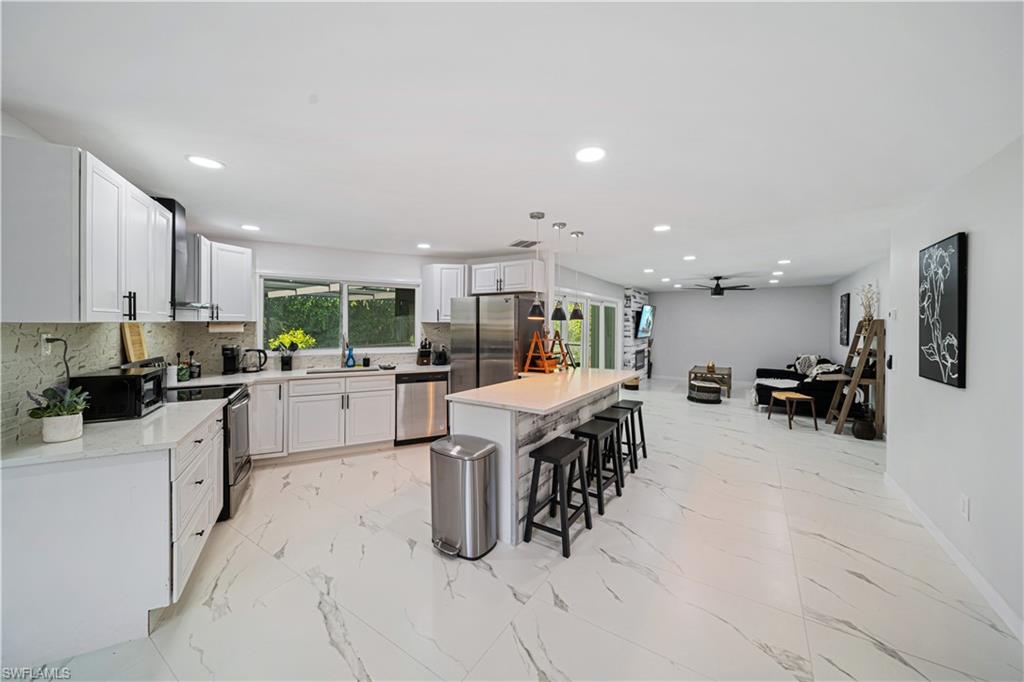 4439 Parrot Avenue Naples, FL 34104 - Photo 13 of 39 a kitchen with cabinets and chairs