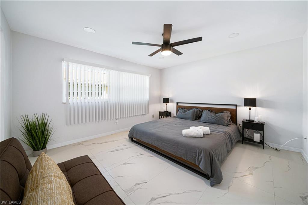 4439 Parrot Avenue Naples, FL 34104 - Photo 16 of 39 a bedroom with a large bed and a window