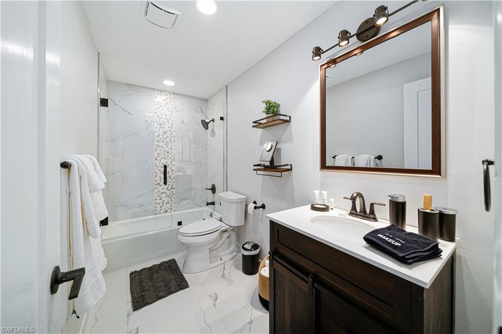 4439 Parrot Avenue Naples, FL 34104 - Photo 24 of 39 a bathroom with a sink a toilet a mirror and shower