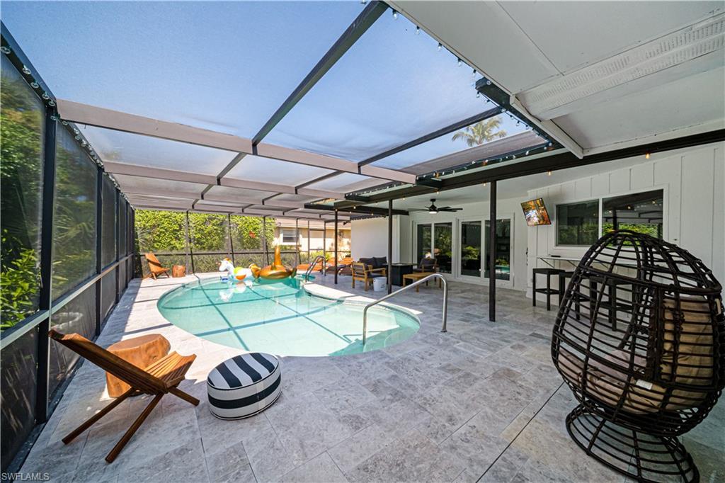 4439 Parrot Avenue Naples, FL 34104 - Photo 36 of 39 a view of a patio with table and chairs potted plants with wooden floor