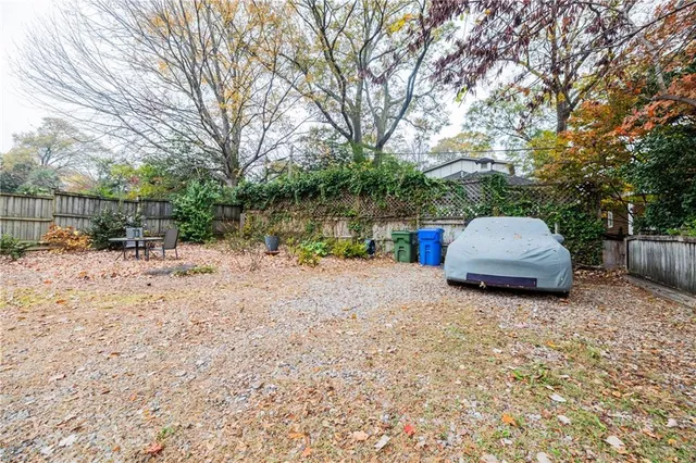 a room with stainless steel appliances kitchen island granite countertop a table chairs and a wooden floor