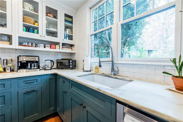 a white bath tub sitting next to a white sink and a mirror