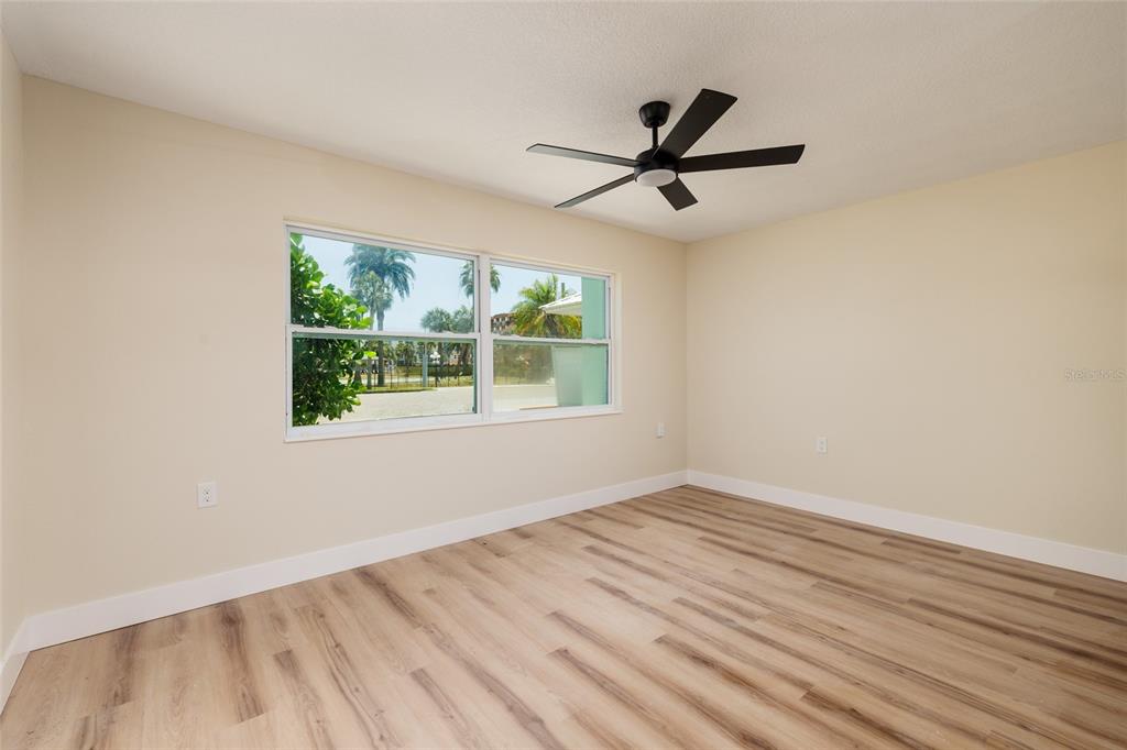 10 164th Avenue, Unit 1 Redington Beach, FL 33708 - Photo 13 of 38 a view of empty room with wooden floor and fan