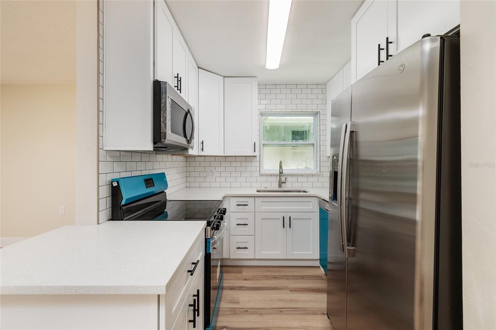 10 164th Avenue, Unit 1 Redington Beach, FL 33708 - Photo 16 of 38 a kitchen with stainless steel appliances a refrigerator sink and cabinets