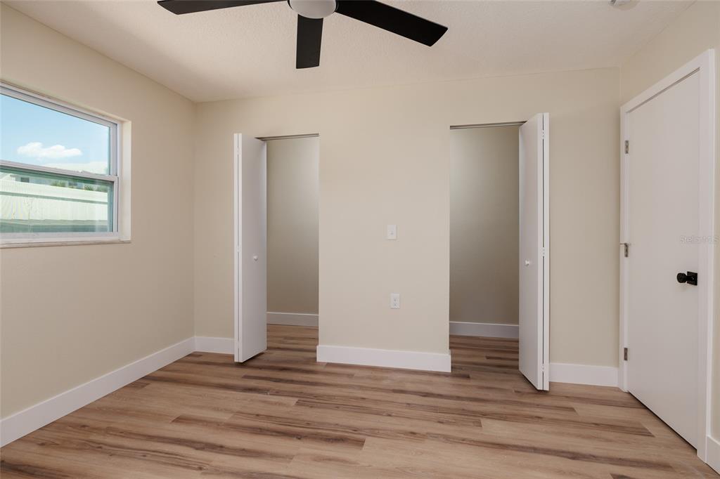 10 164th Avenue, Unit 1 Redington Beach, FL 33708 - Photo 19 of 38 an empty room with wooden floor cabinet and windows