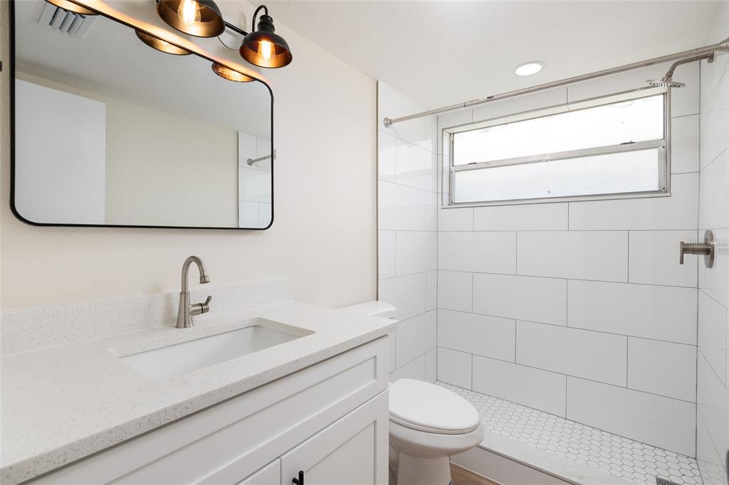 10 164th Avenue, Unit 1 Redington Beach, FL 33708 - Photo 20 of 38 a bathroom with a sink a toilet and mirror
