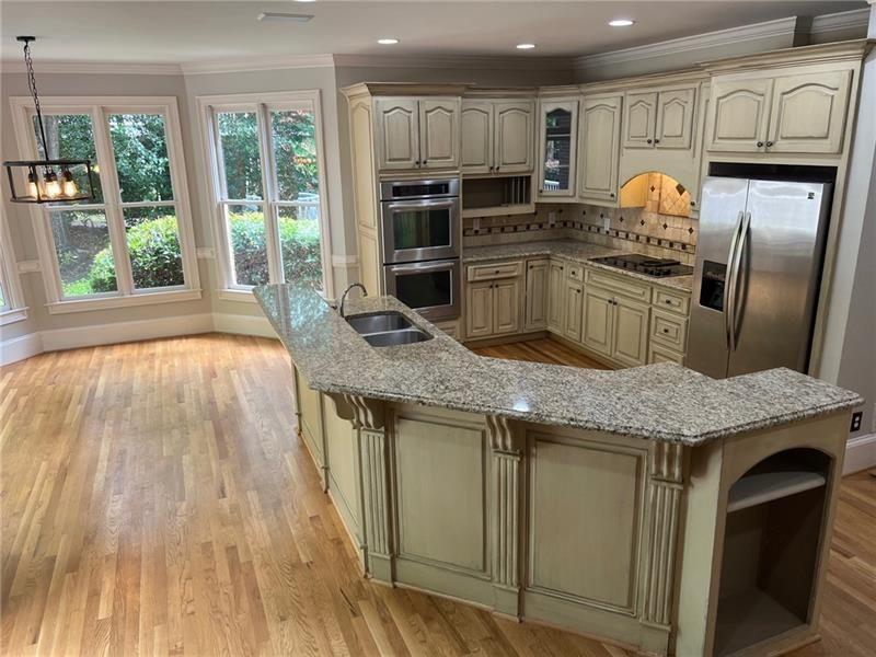 2728 Chieftain Run Duluth, GA 30097 - Photo 6 of 17 a kitchen with stainless steel appliances granite countertop a kitchen island wooden cabinets and a granite counter tops