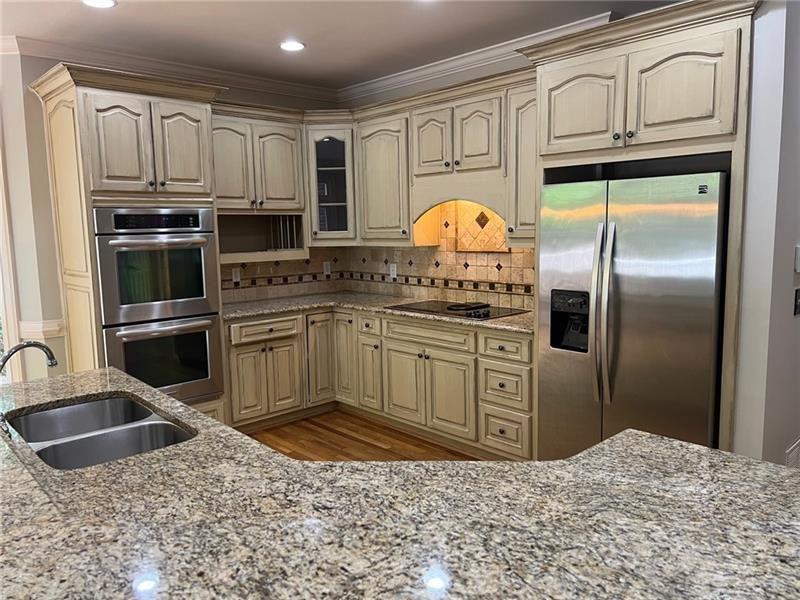 2728 Chieftain Run Duluth, GA 30097 - Photo 8 of 17 a kitchen with stainless steel appliances granite countertop a stove a sink and a refrigerator